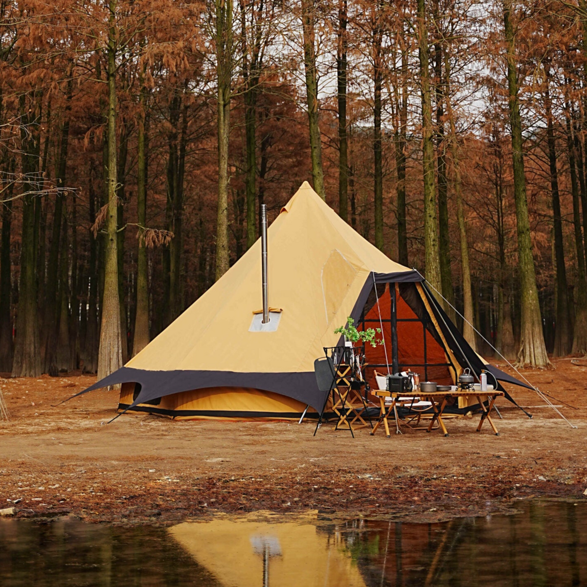 Yellow bell tent with outdoor furniture in a forest setting